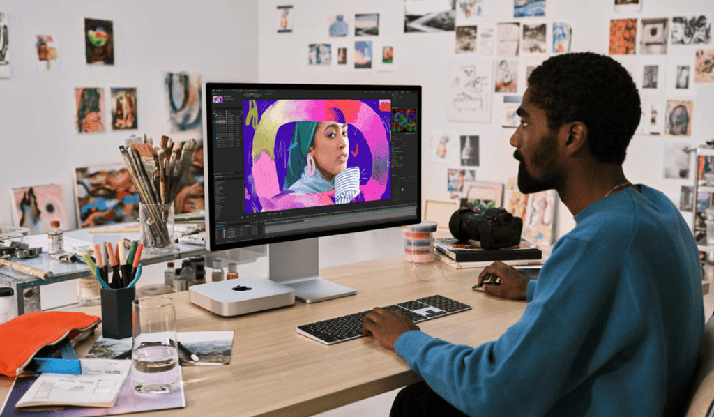 Persona trabajando en un escritorio con una Mac mini.